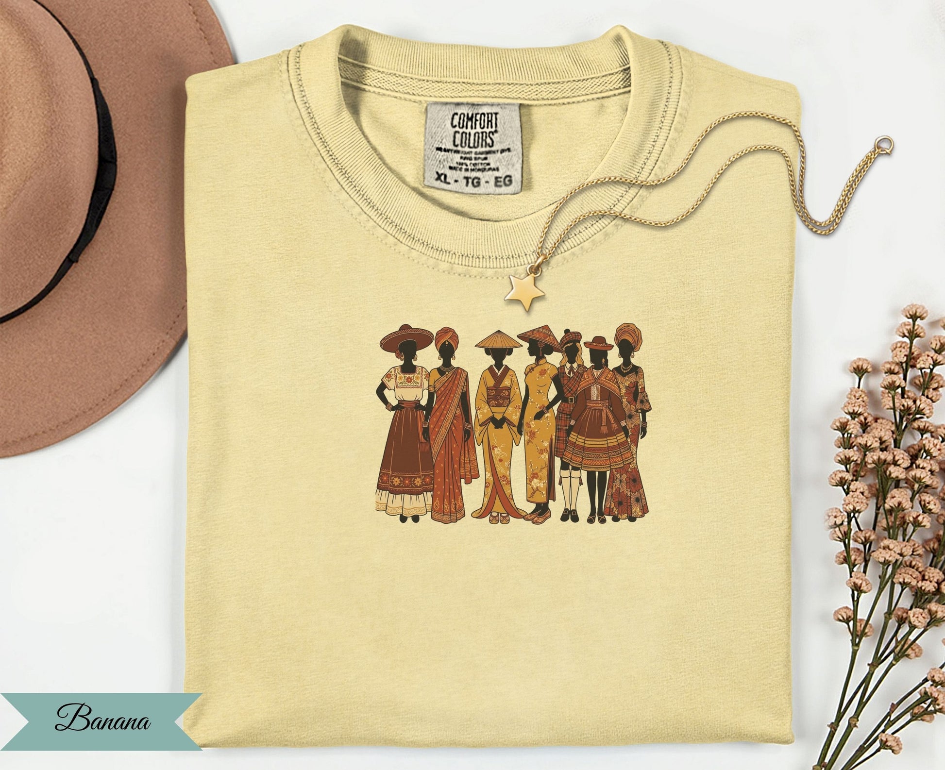 T-shirt featuring diverse women in traditional attire, with a gold necklace and hat.
