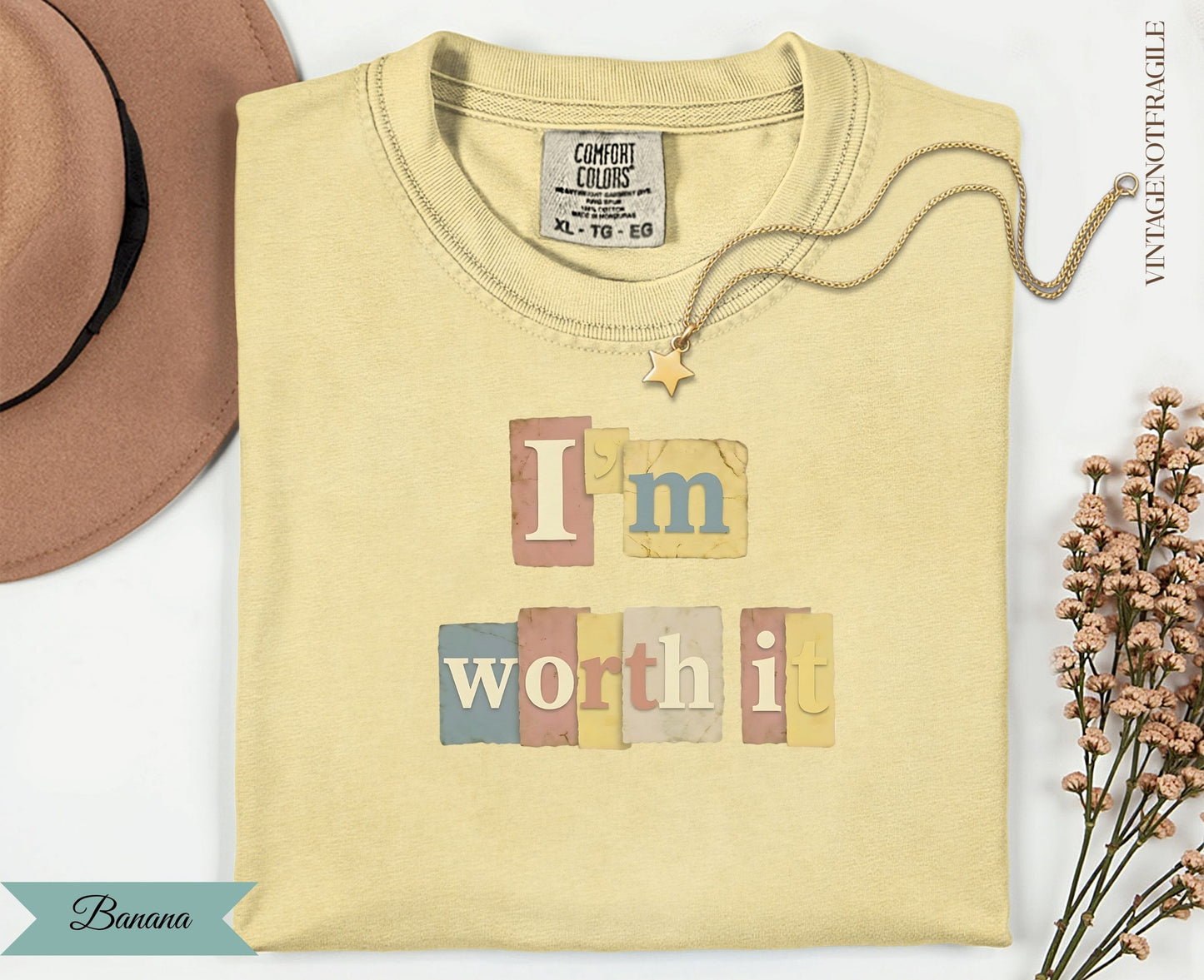 Light yellow t-shirt with "I'm worth it" in pastel blocks and a gold necklace.