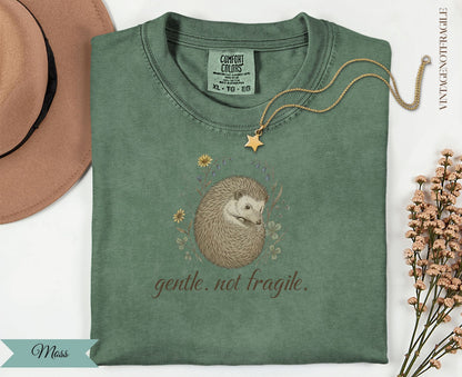 Green t-shirt with a hedgehog and floral illustration and text.