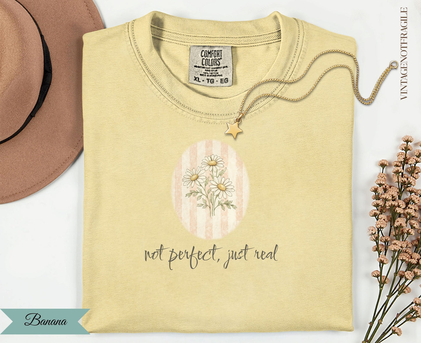 Yellow t-shirt with "not perfect, just real" text and floral graphic.