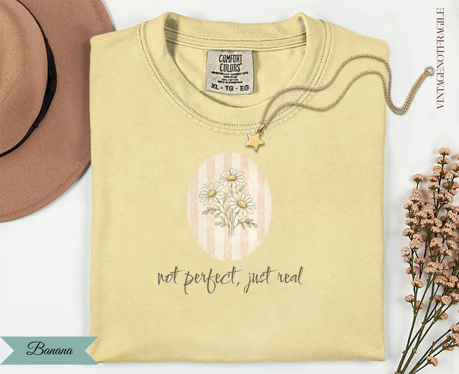 Yellow t-shirt with "not perfect, just real" text and floral graphic.