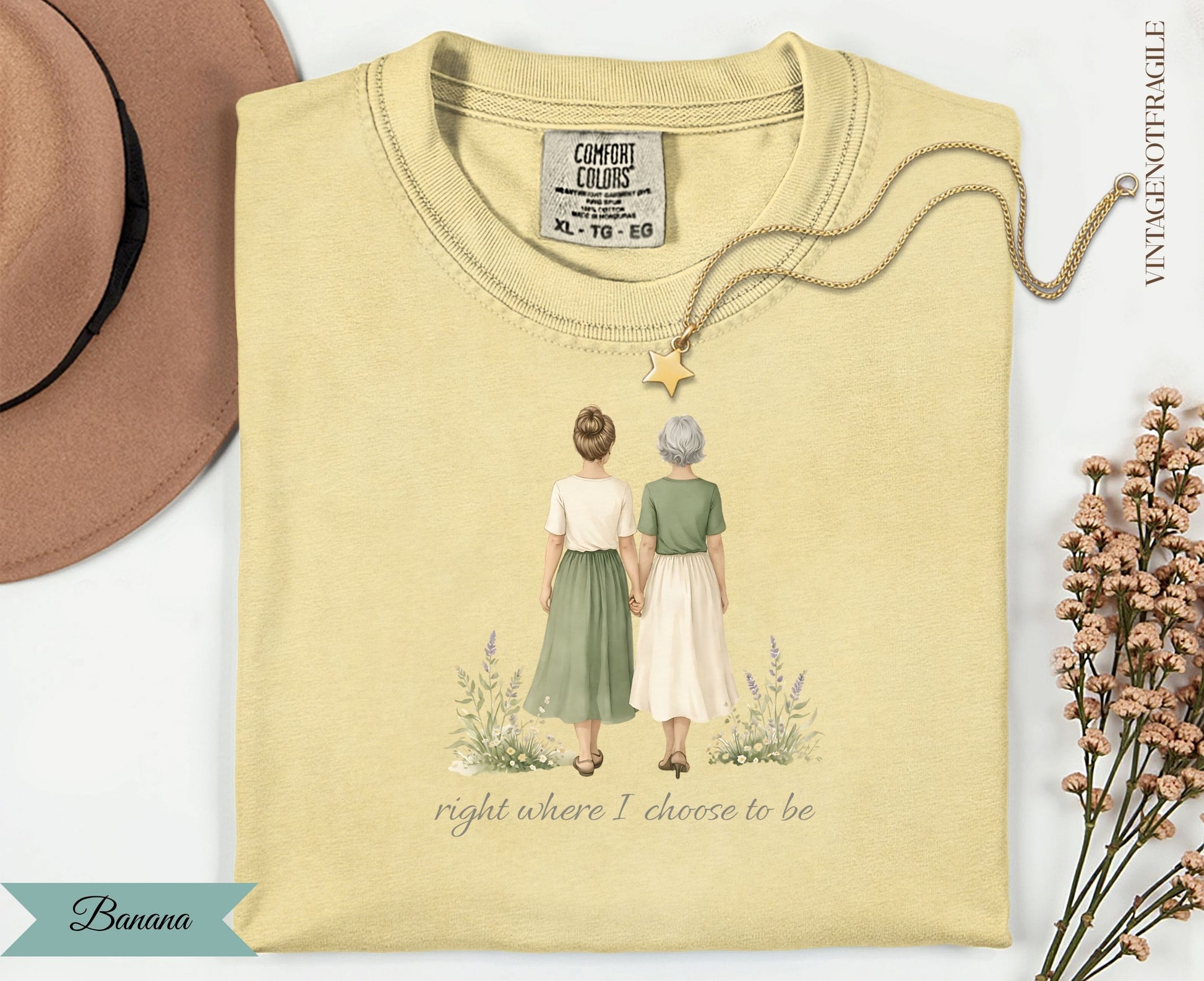 Yellow t-shirt with illustration of two women holding hands, text reads "right where I choose to be".