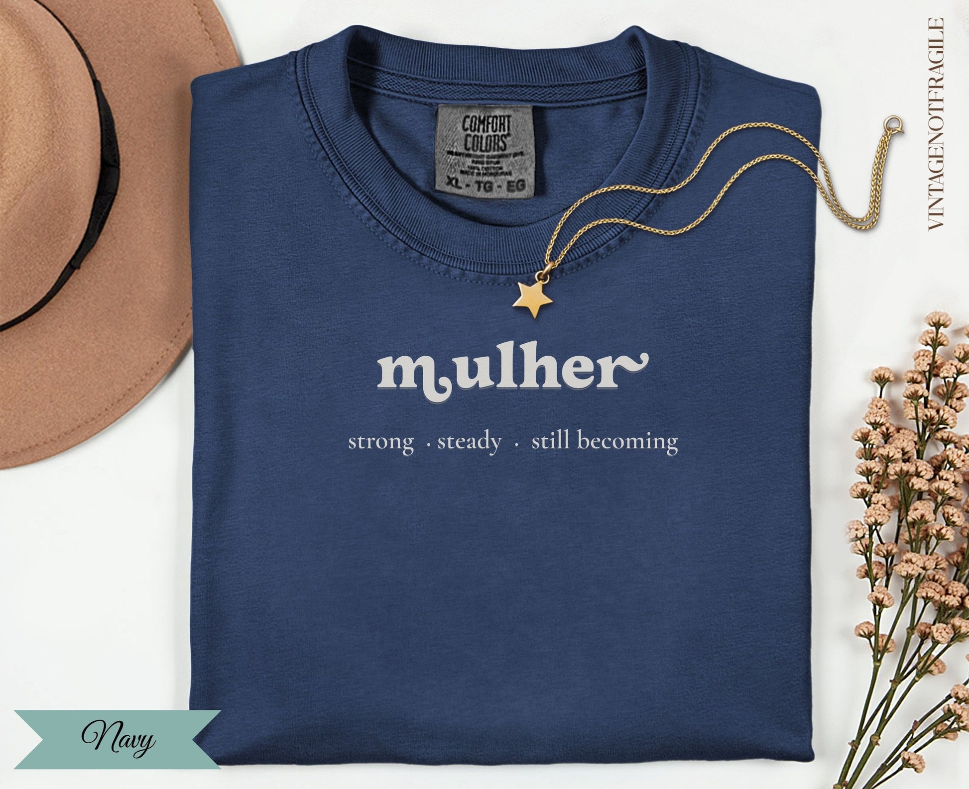 Navy t-shirt with "mulher strong steady. still becoming" text.