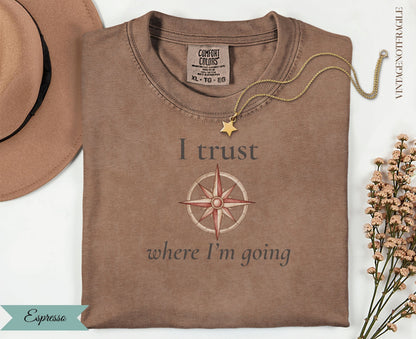 Brown t-shirt with compass and "I trust where I'm going" text.