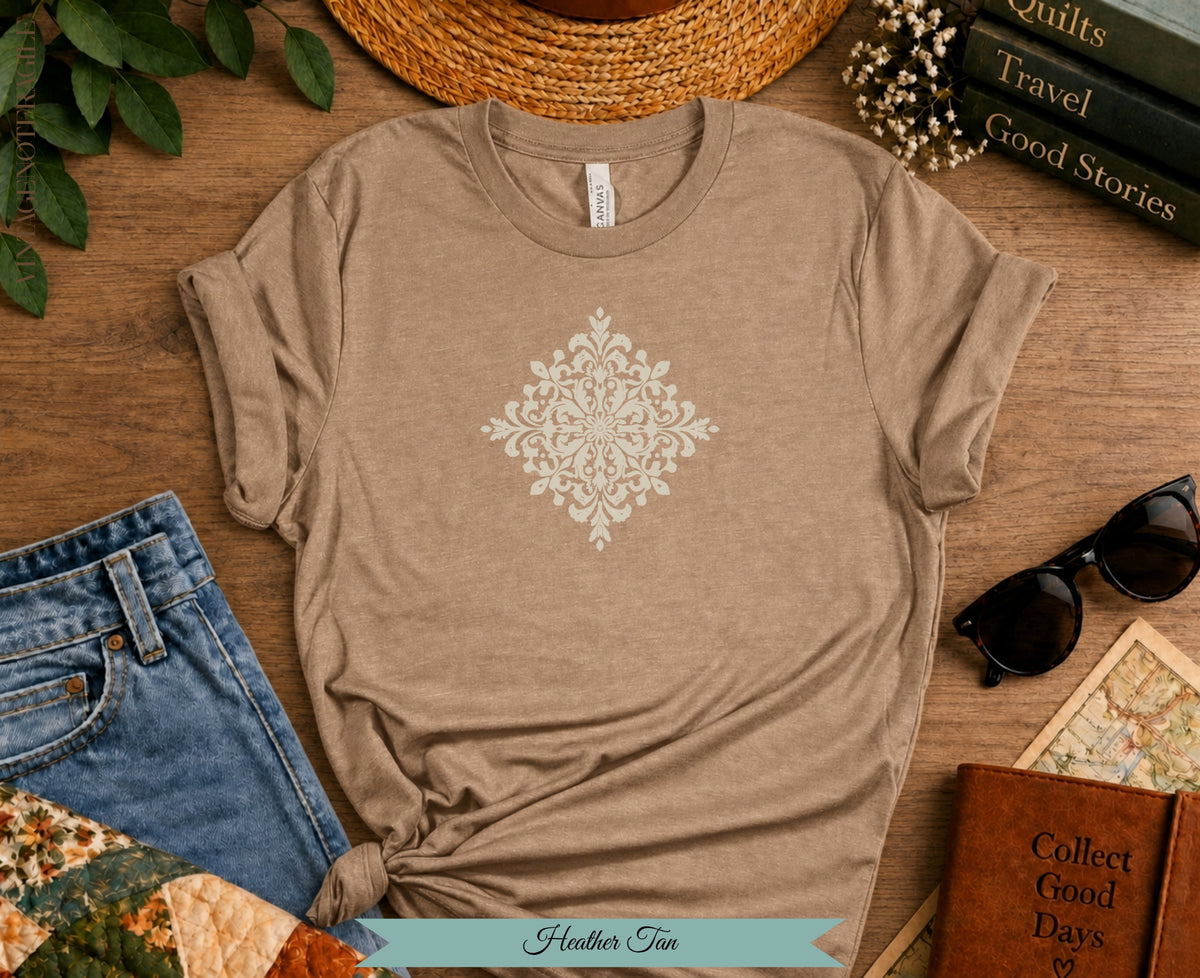 Heather Tan t-shirt with cream ornate mandala graphic and jeans.
