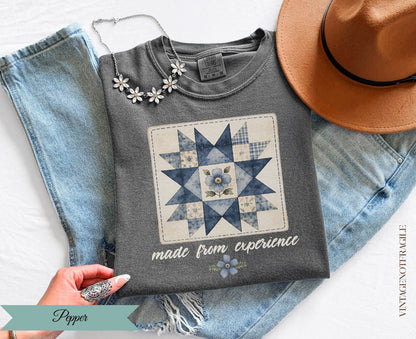 Gray t-shirt with a blue quilt design and "made from experience" text.