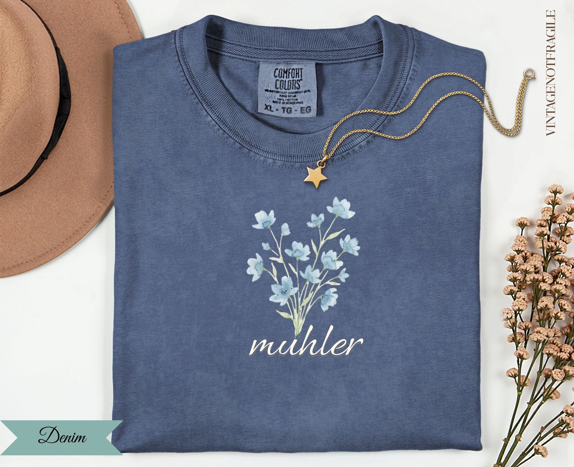 Blue t-shirt with delicate blue flowers and "muhler" text.