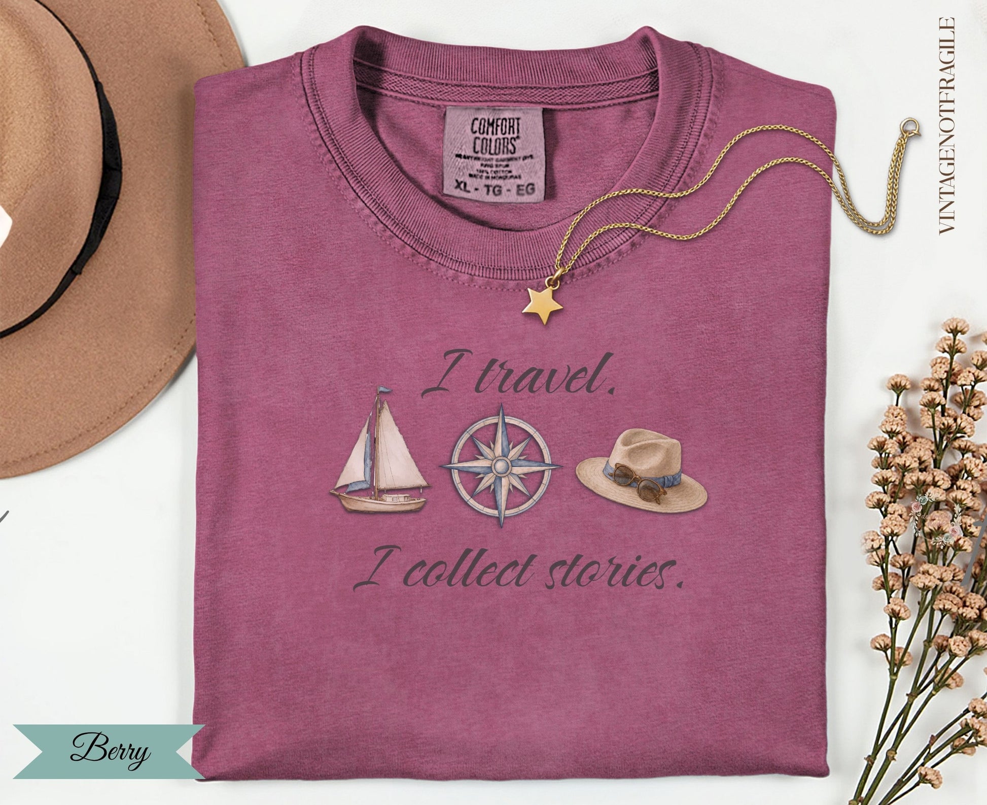Berry colored t-shirt with "I travel. I collect stories." and travel icons.