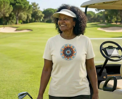 Woman in light t-shirt with colorful mandala print standing by golf cart.