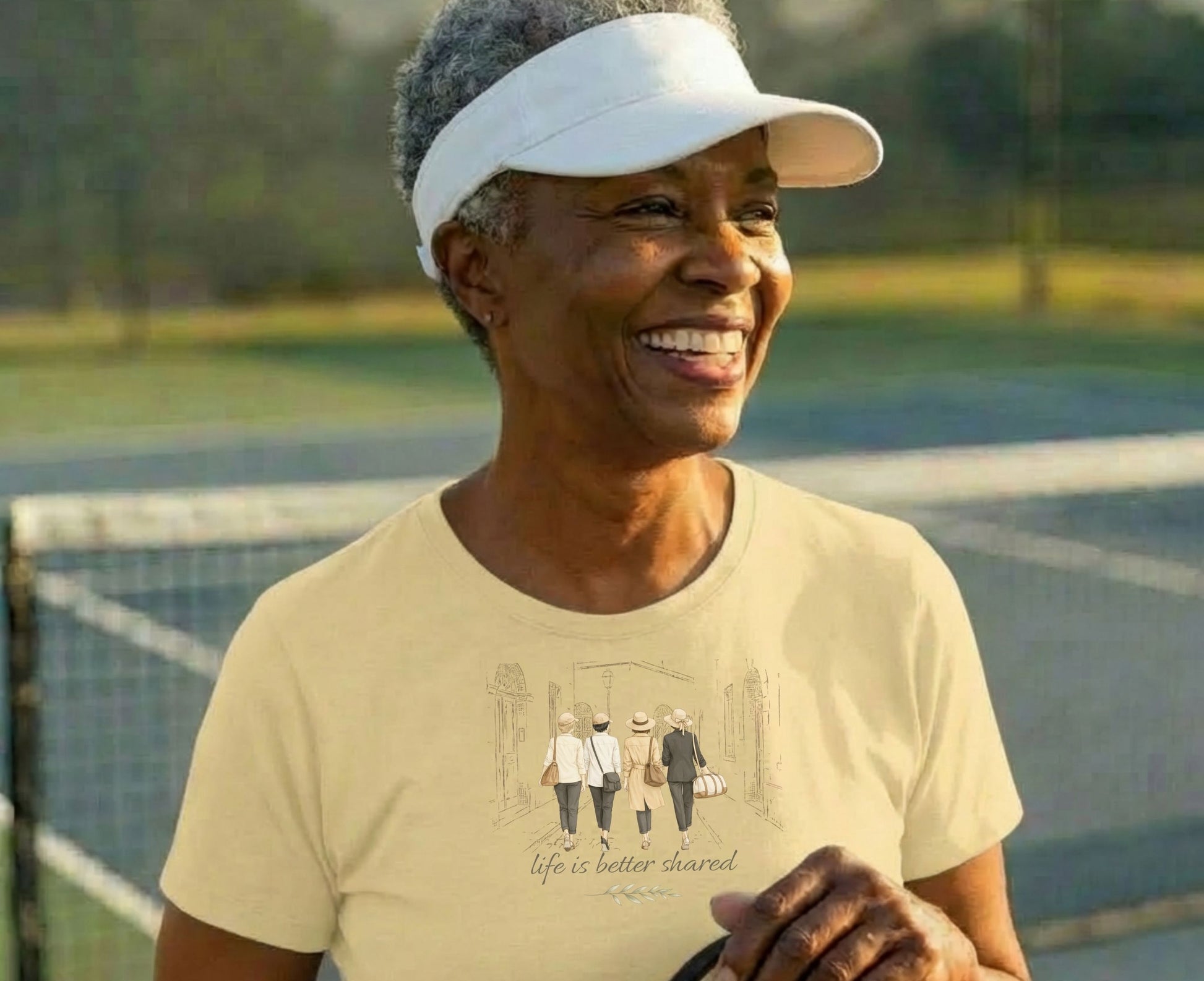 Woman wearing a light yellow t-shirt with a graphic of people walking.