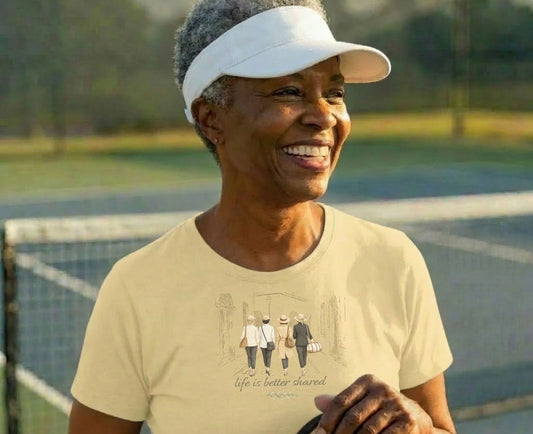 Woman wearing a light yellow t-shirt with a graphic of people walking.