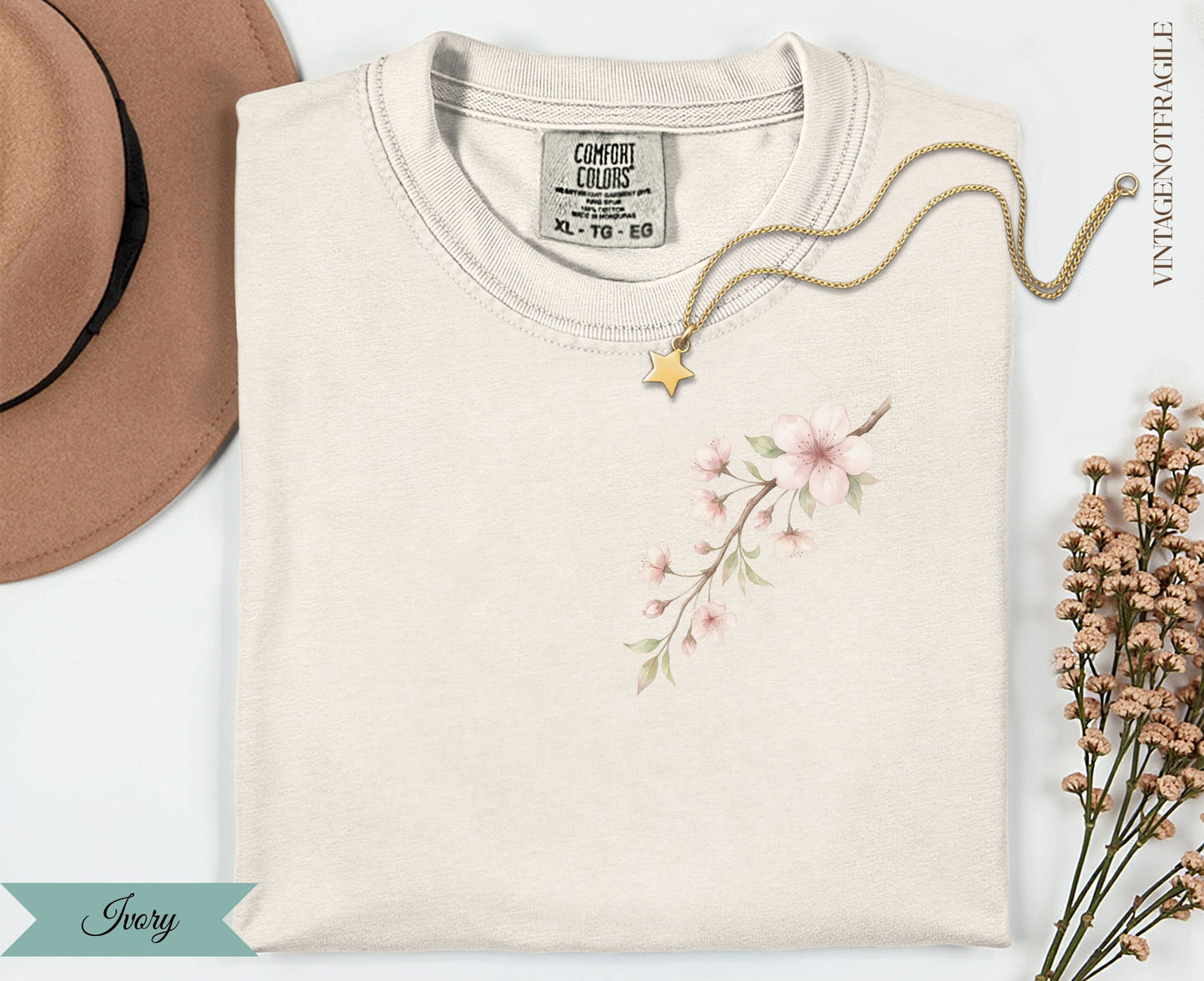 Cream t-shirt with delicate pink cherry blossoms and a small gold star necklace.