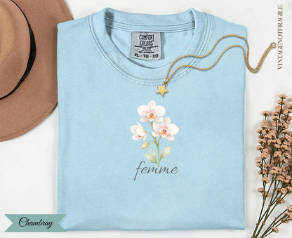 Light blue t-shirt with watercolor orchids and the word "femme".