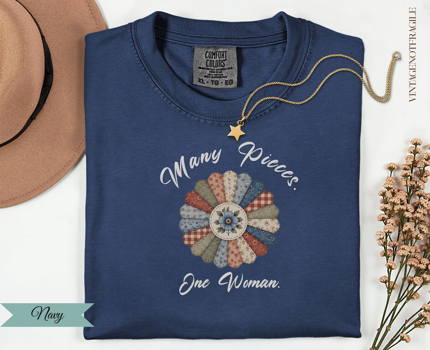 Navy t-shirt with "Many Pieces. One Woman." floral quilt design.
