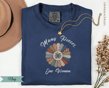Navy t-shirt with "Many Pieces. One Woman." floral quilt design.