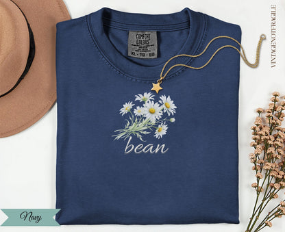 Navy t-shirt with "bean" and a daisy bouquet graphic.