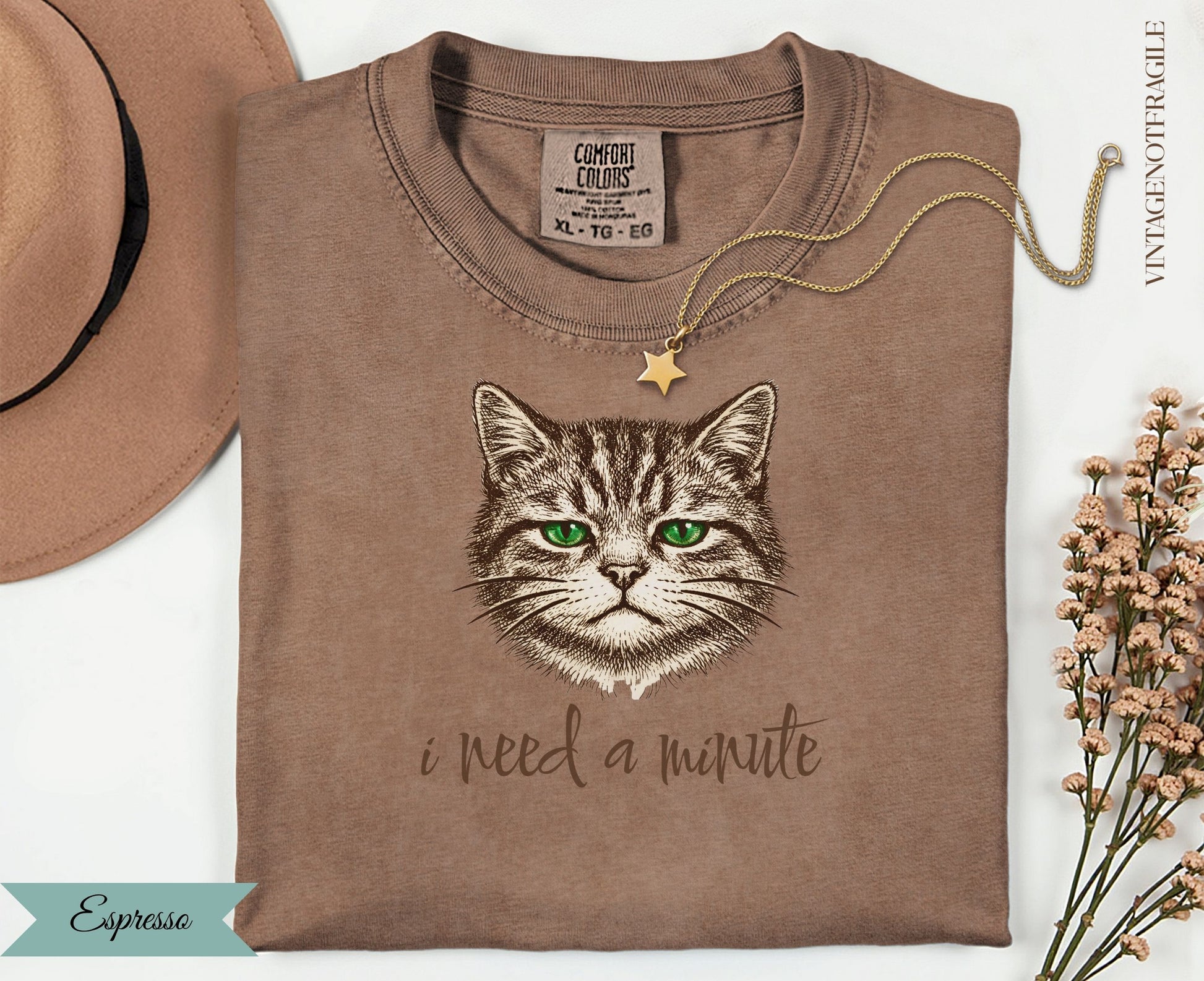 Brown t-shirt with a cat's face and "i need a minute" text.