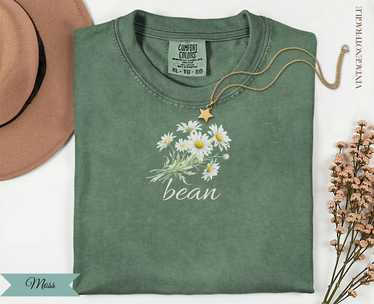 Green t-shirt with white daisies and "bean" text.