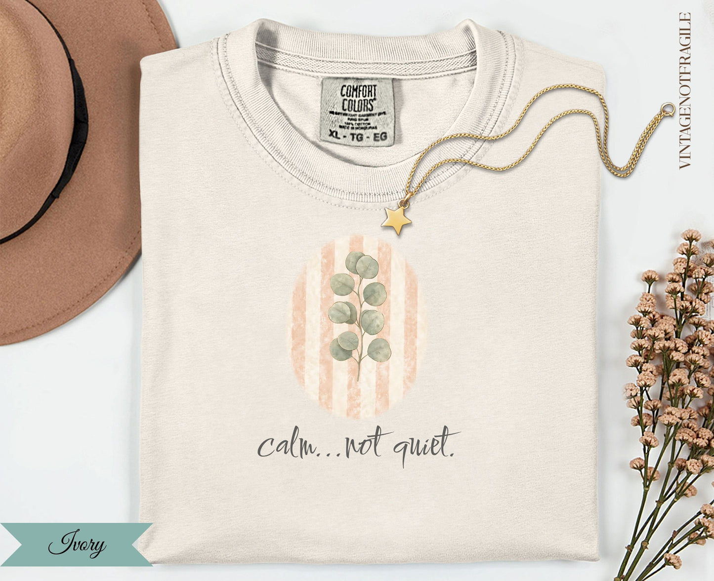 Cream t-shirt with eucalyptus branch and pastel stripes, text "calm... not quiet."