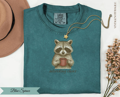 T-shirt with a raccoon holding a coffee cup and the text "interesting choice".