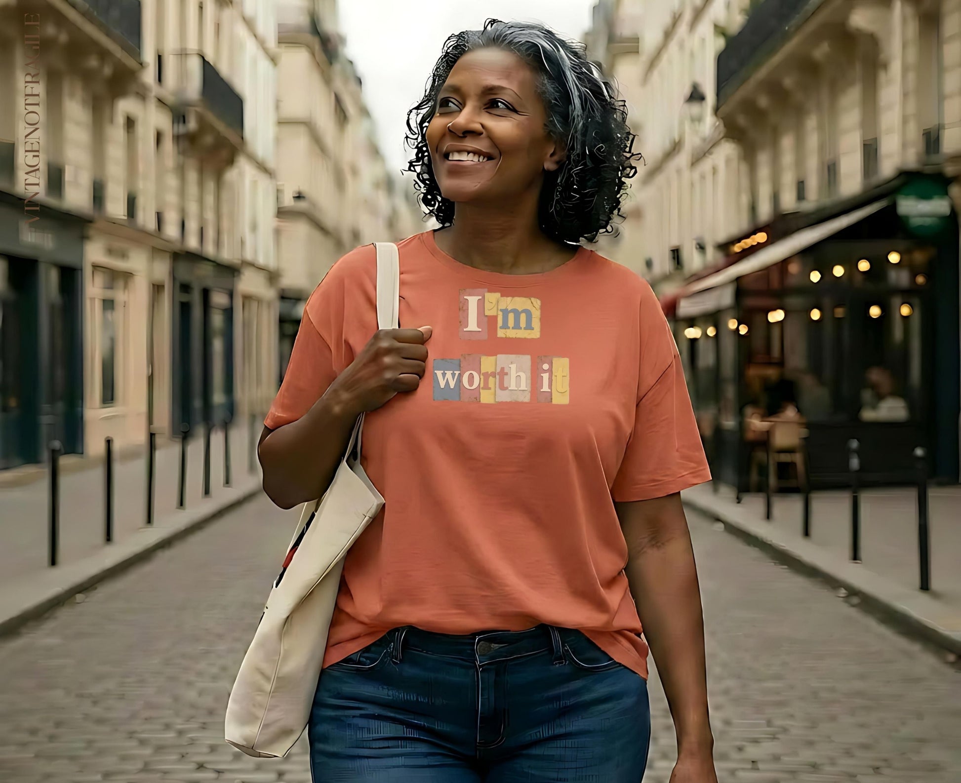 Woman wearing an orange t-shirt with "I'm worth it" text, walking on a street.
