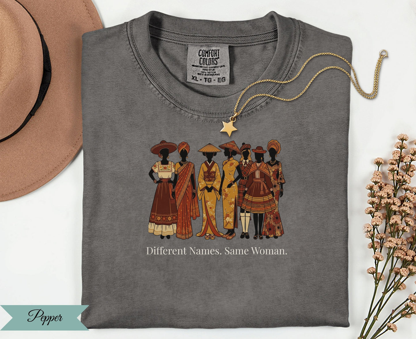 T-shirt with seven women in diverse traditional clothing and text "Different Names. Same Woman."