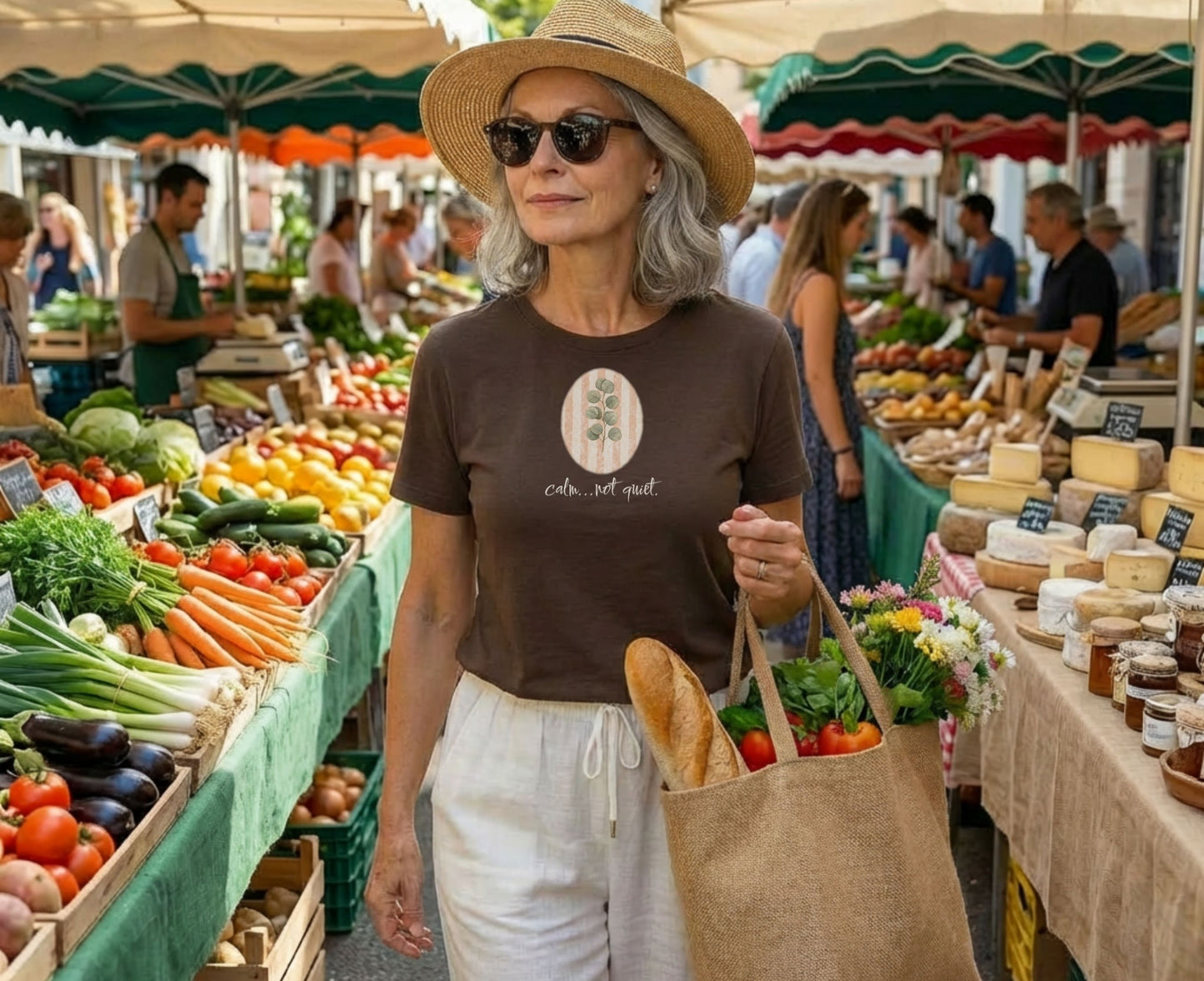 Woman wearing a hat and sunglasses at a farmer's market.