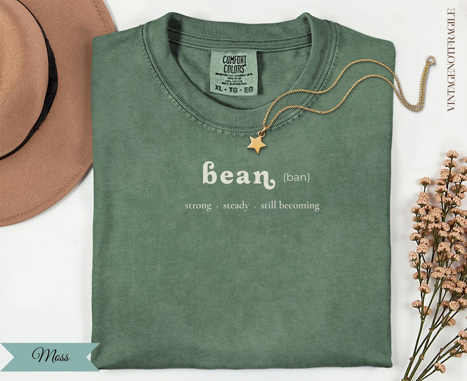 Green Comfort Colors t-shirt with "bean" and "strong steady still becoming" text.