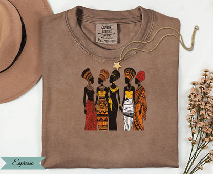 Five women in traditional African attire stand together, wearing an Espresso colored t-shirt.