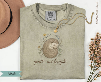 Khaki t-shirt with a hedgehog illustration and "gentle. not fragile." text.