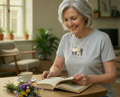 Woman reading a book with a graphic of four women walking on her shirt.