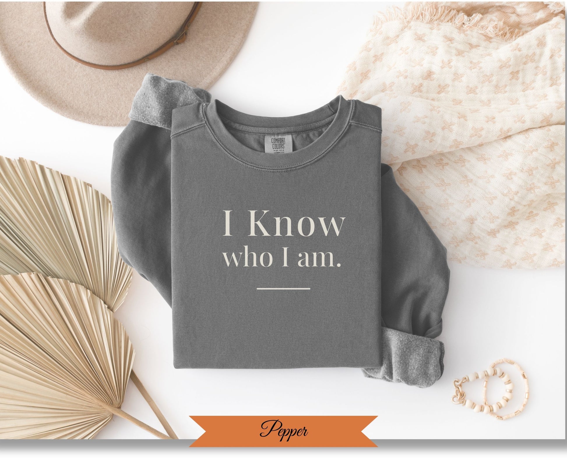 Grey sweatshirt with "I Know who I Am." text and "Popper" label.
