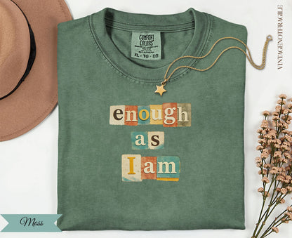 Green t-shirt with "enough as I am" in colorful block letters.