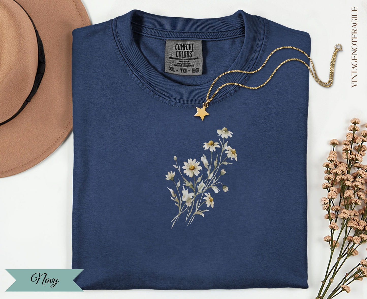 Navy t-shirt with delicate white daisy bouquet graphic and gold chain necklace.