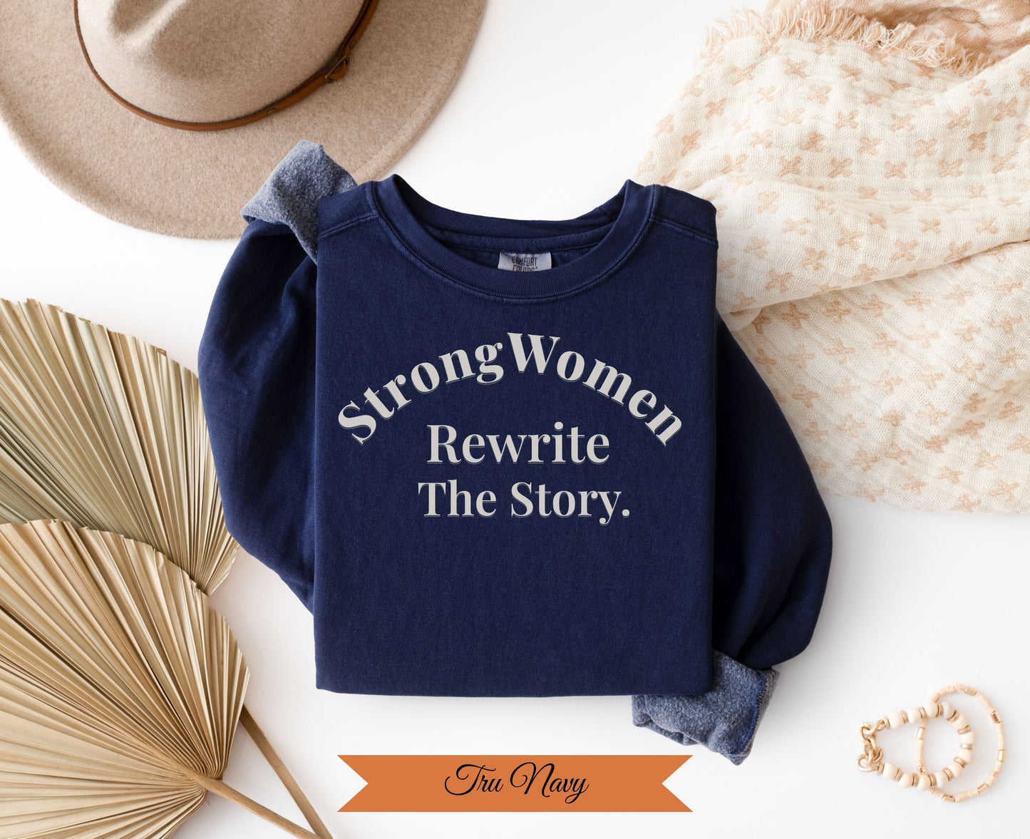 Navy sweatshirt with "Strong Women Rewrite The Story" text.