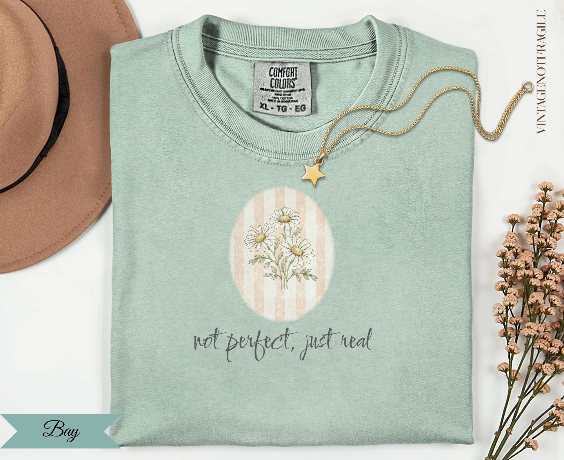 Light green t-shirt with "not perfect, just real" and daisy graphic.