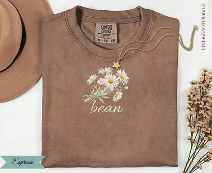 Brown Comfort Colors t-shirt with daisy bouquet and "bean" text.