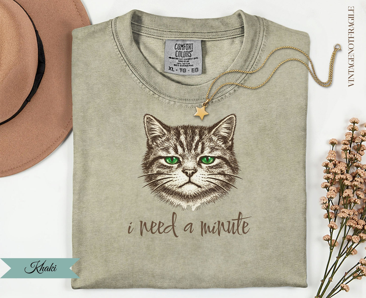 Khaki t-shirt with a cat illustration and "i need a minute" text.