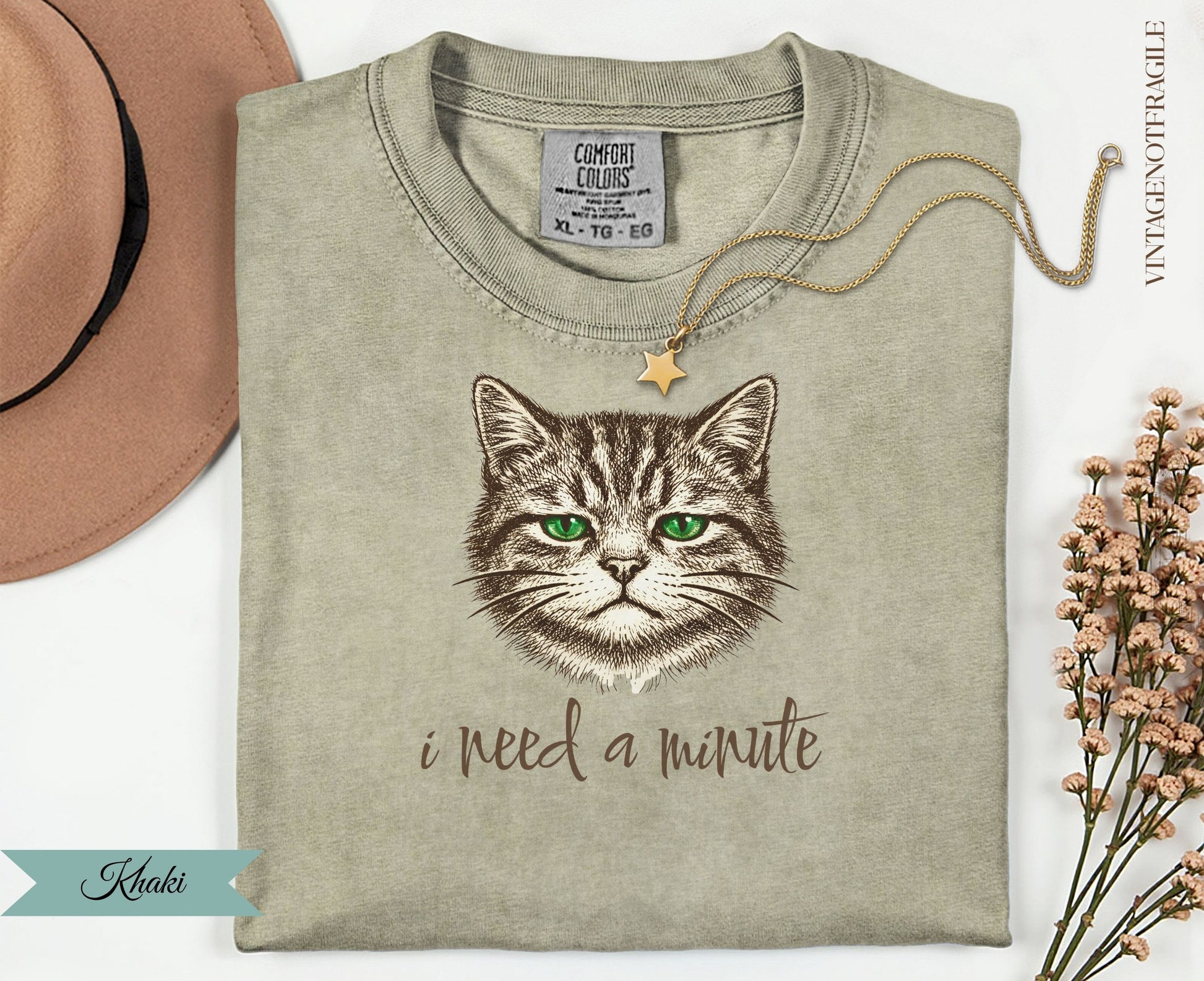 Khaki t-shirt with a cat illustration and "i need a minute" text.