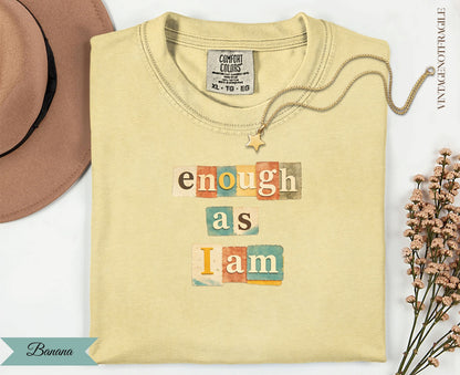 Yellow t-shirt with "enough as I am" text in colorful blocks.