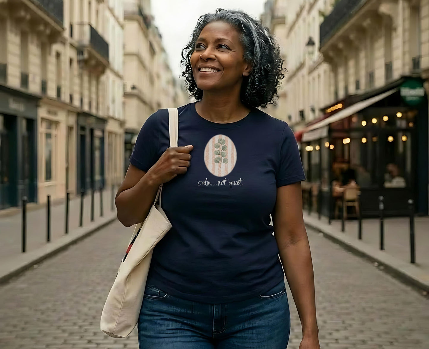 Woman wearing a navy t-shirt with "Calm, not quiet" text and eucalyptus graphic.