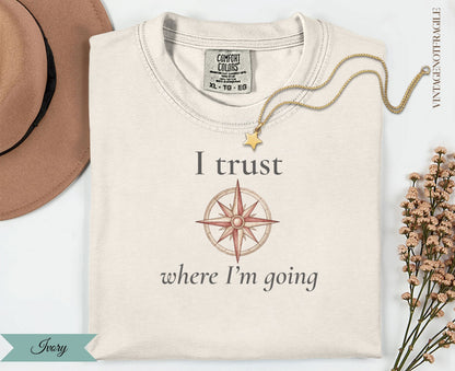 Cream t-shirt with compass and "I trust where I'm going" text.
