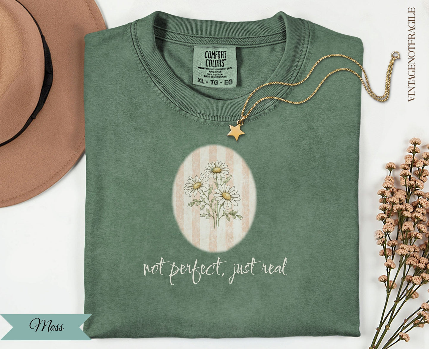 Green t-shirt with daisies, text "not perfect, just real", and "Moss".