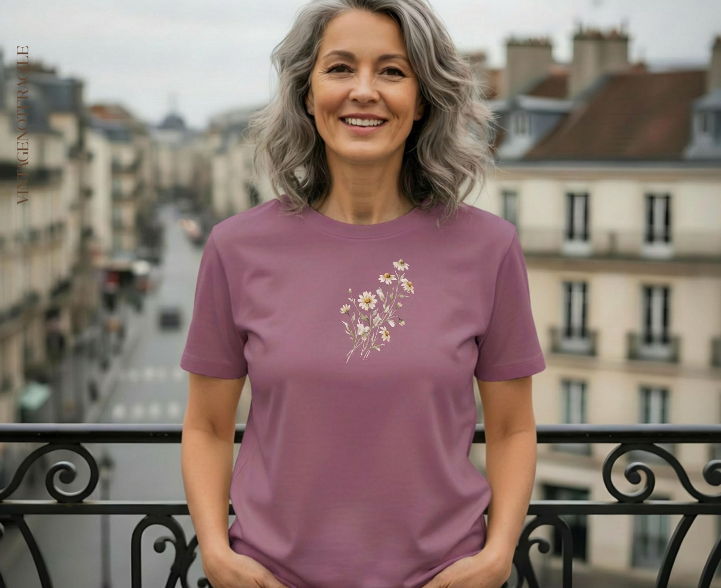 Woman wearing dusty rose t-shirt with small floral embroidery.