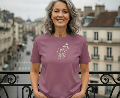 Woman wearing dusty rose t-shirt with small floral embroidery.