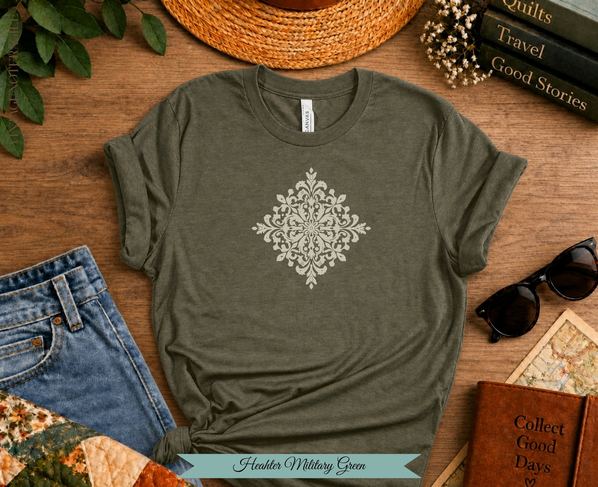 Olive green t-shirt with white mandala graphic, jeans, and accessories.