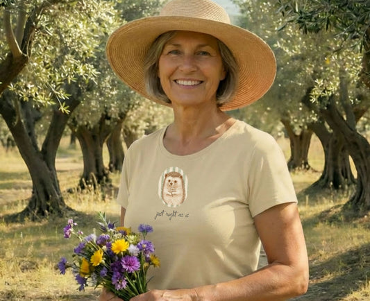 Woman wearing a t-shirt with a hedgehog graphic, holding a bouquet of flowers outdoors.