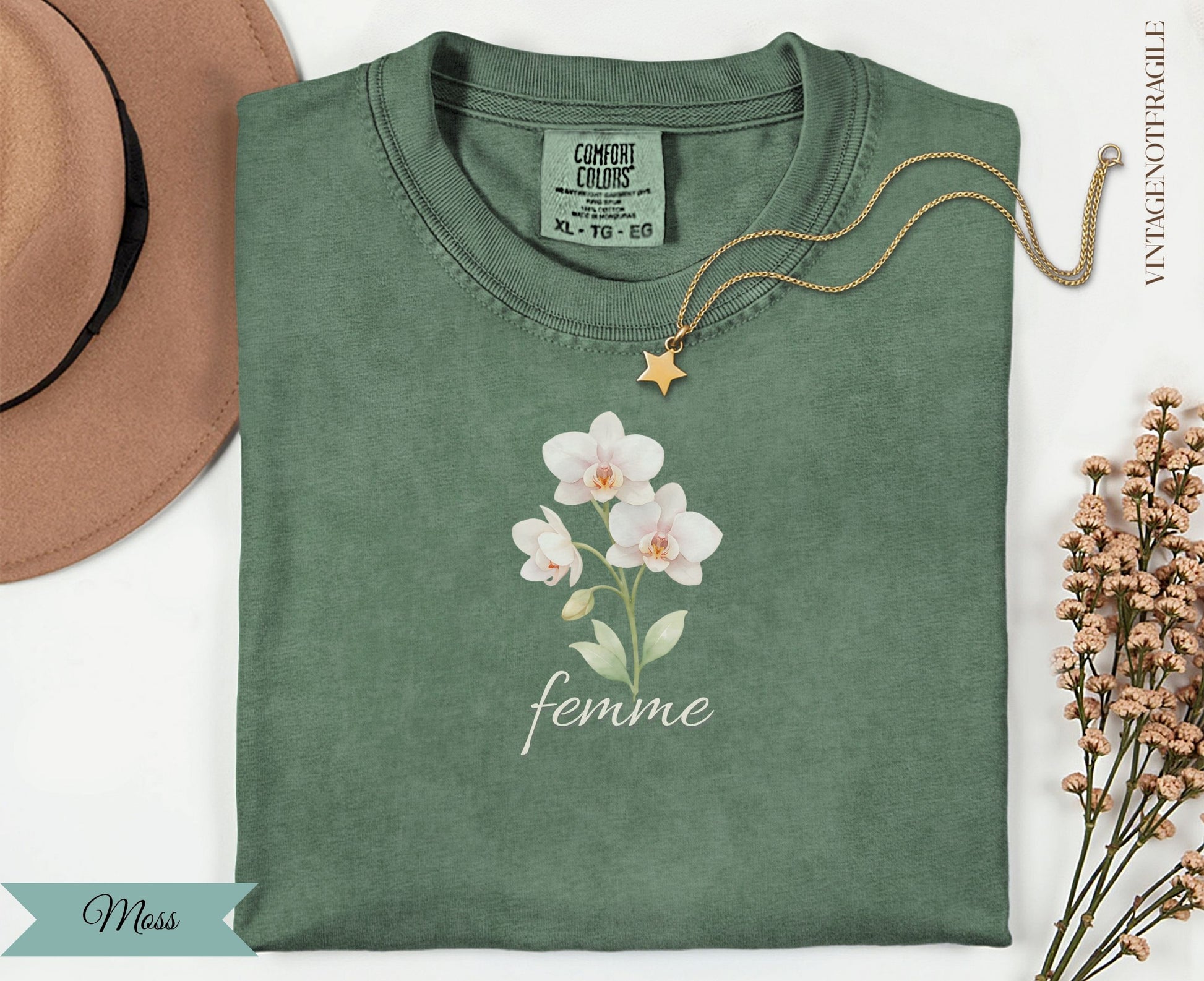 Green t-shirt with white orchid flowers and "femme" text.