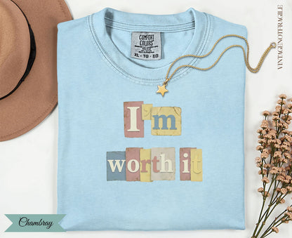Light blue t-shirt with "I'm worth it" text and a small gold star charm.