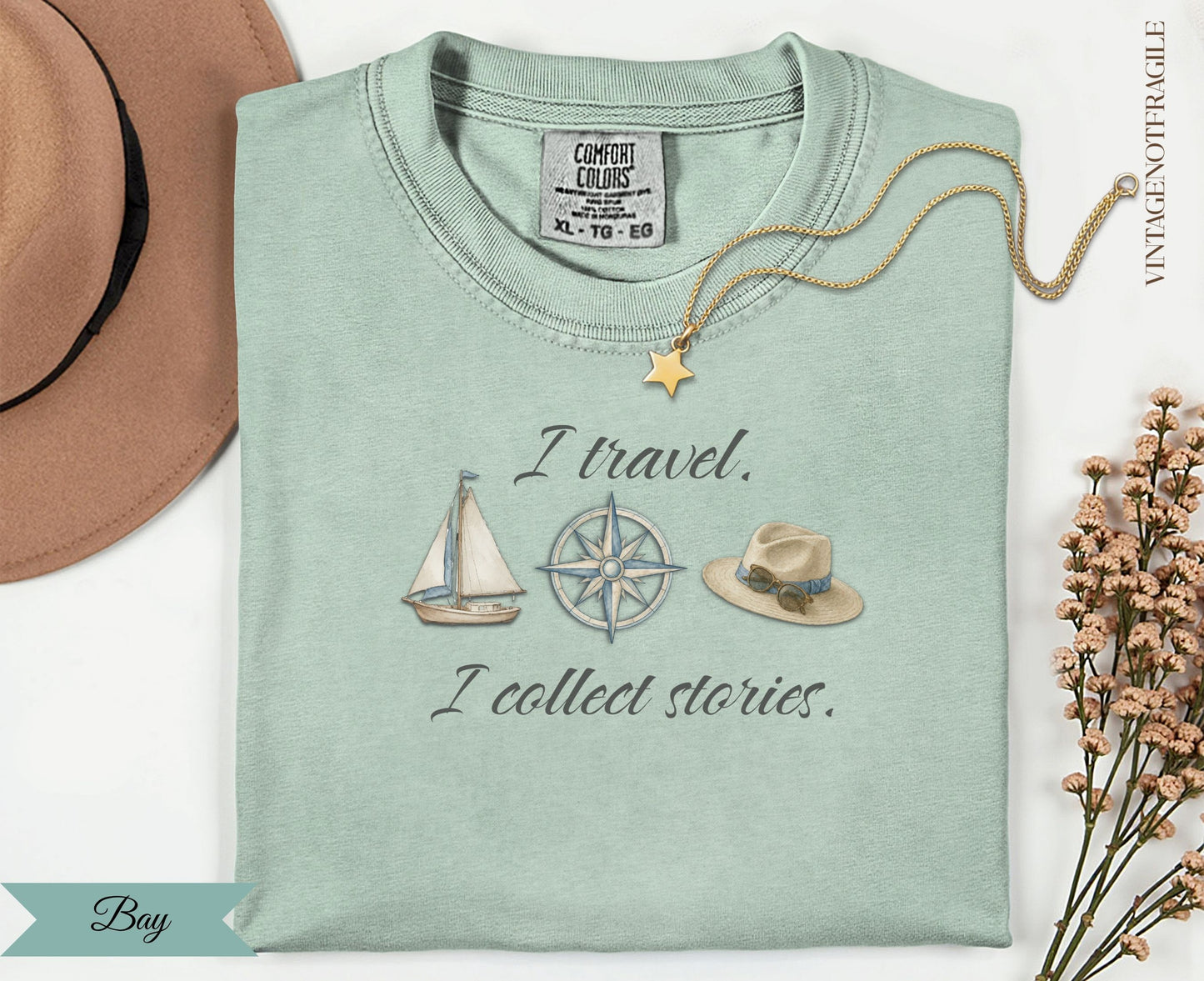Pale green t-shirt with "I travel. I collect stories." and nautical illustrations.